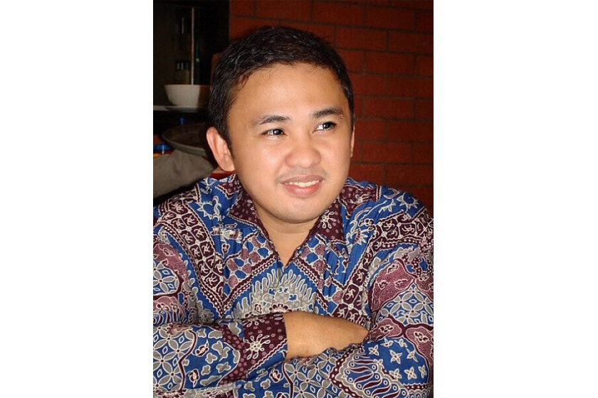 A man wearing batik shirt crossing arms